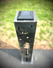 Solar-powered garden column with decorative cutouts on a grassy background