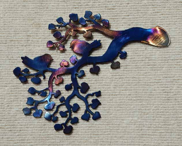 Metallic blue and purple tree-like sculpture on a textured beige background