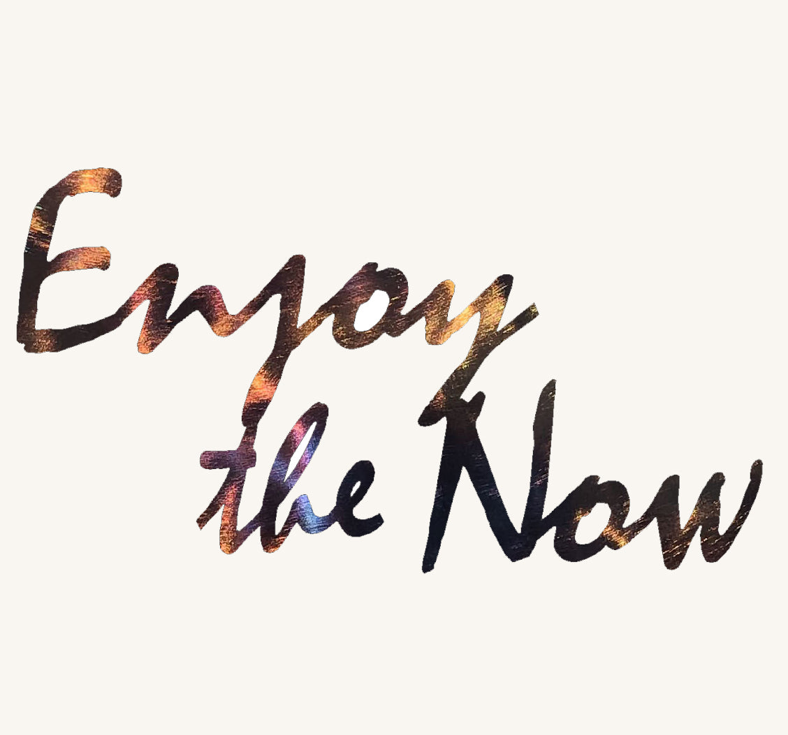 Text 'Enjoy the Now' with a gradient effect on a white background