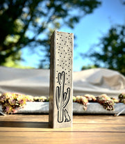 Metal Pillar with cactus design on a wooden surface outdoors