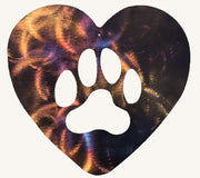 Heart-shaped metal cutout with a white paw print design on a multicolored background