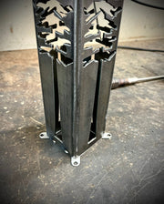 Metal decorative garden pillar with cut-out design on a concrete floor