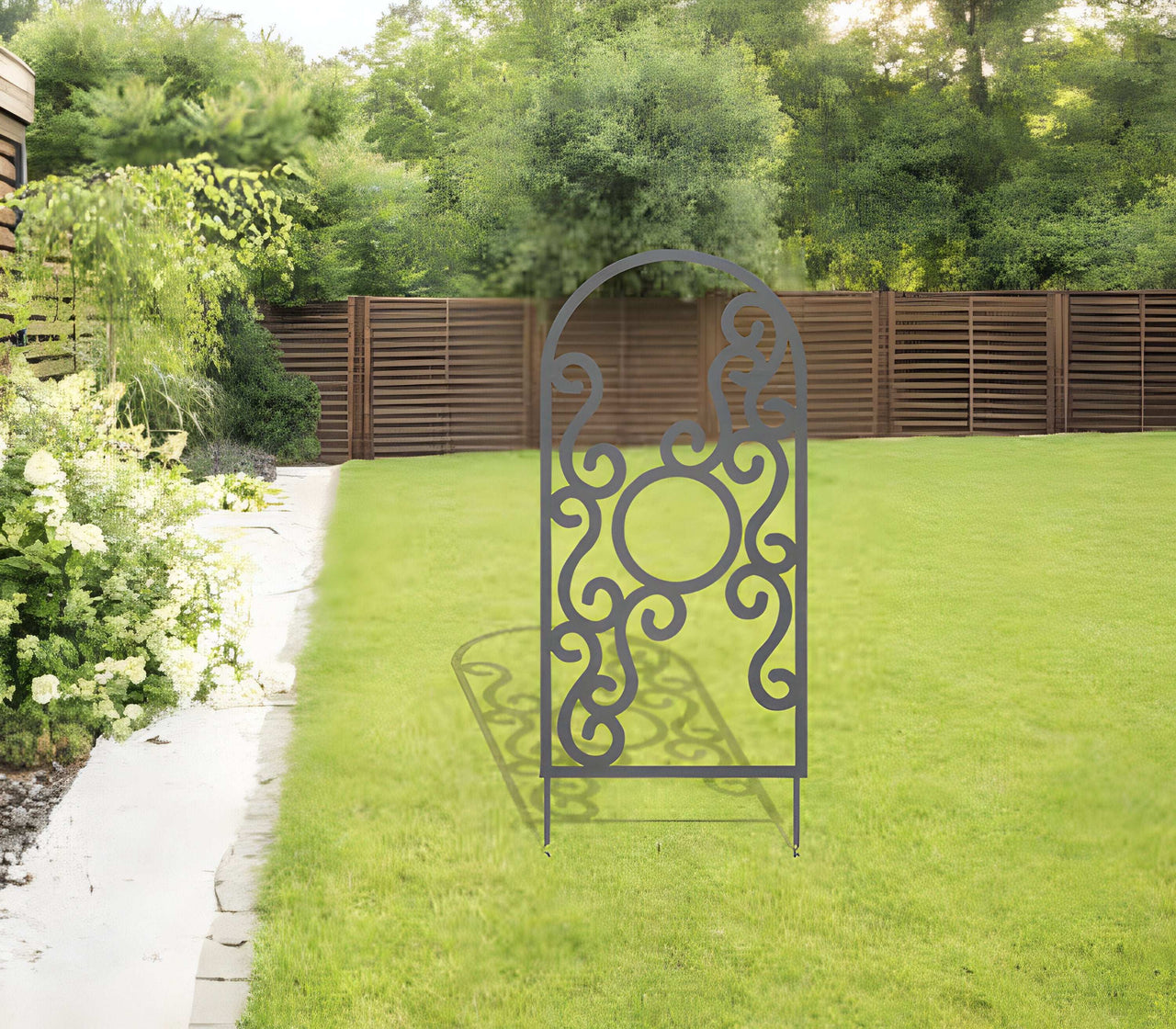 A metal garden trellis with stakes in a field