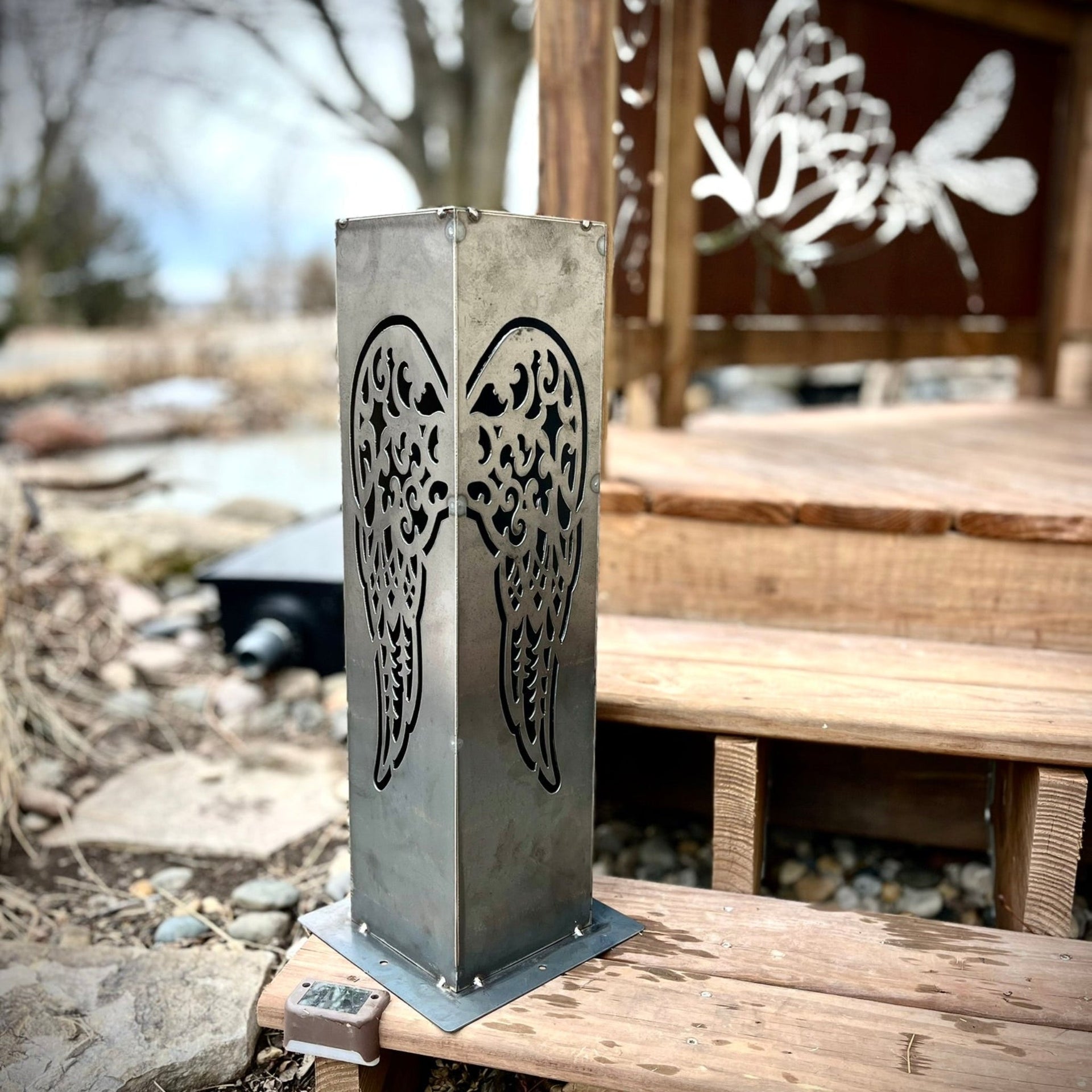 Metal decorative pillar with cut-out design on a wooden bench outdoors