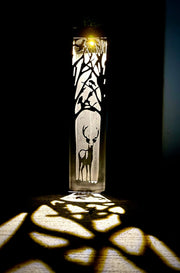 Decorative Vertical Garden Column with deer design casting shadows on a dark background