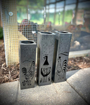 Three Garden Column Pillars with rooster designs on a concrete surface.