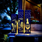 Garden Column Pillars with rooster designs on a wooden post at night.
