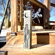 Metal Pillar with cactus and moon design on a wooden surface outdoors