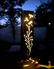 Decorative outdoor garden pillar with floral patterns on a dark background