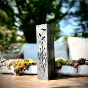Decorative garden pillar with floral design on a table outdoors