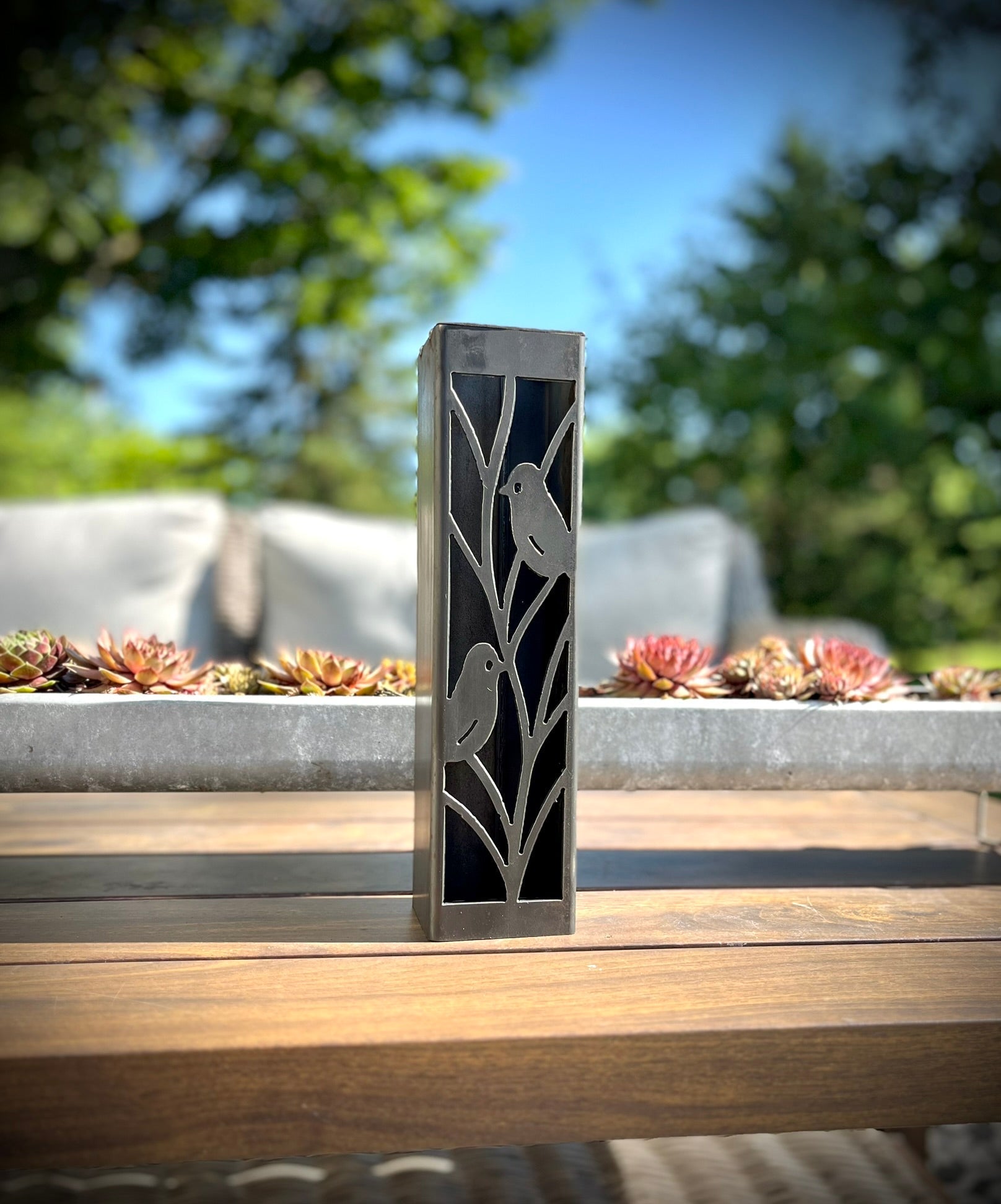 Outdoor Decorative Column with bird design on a wooden surface outdoors