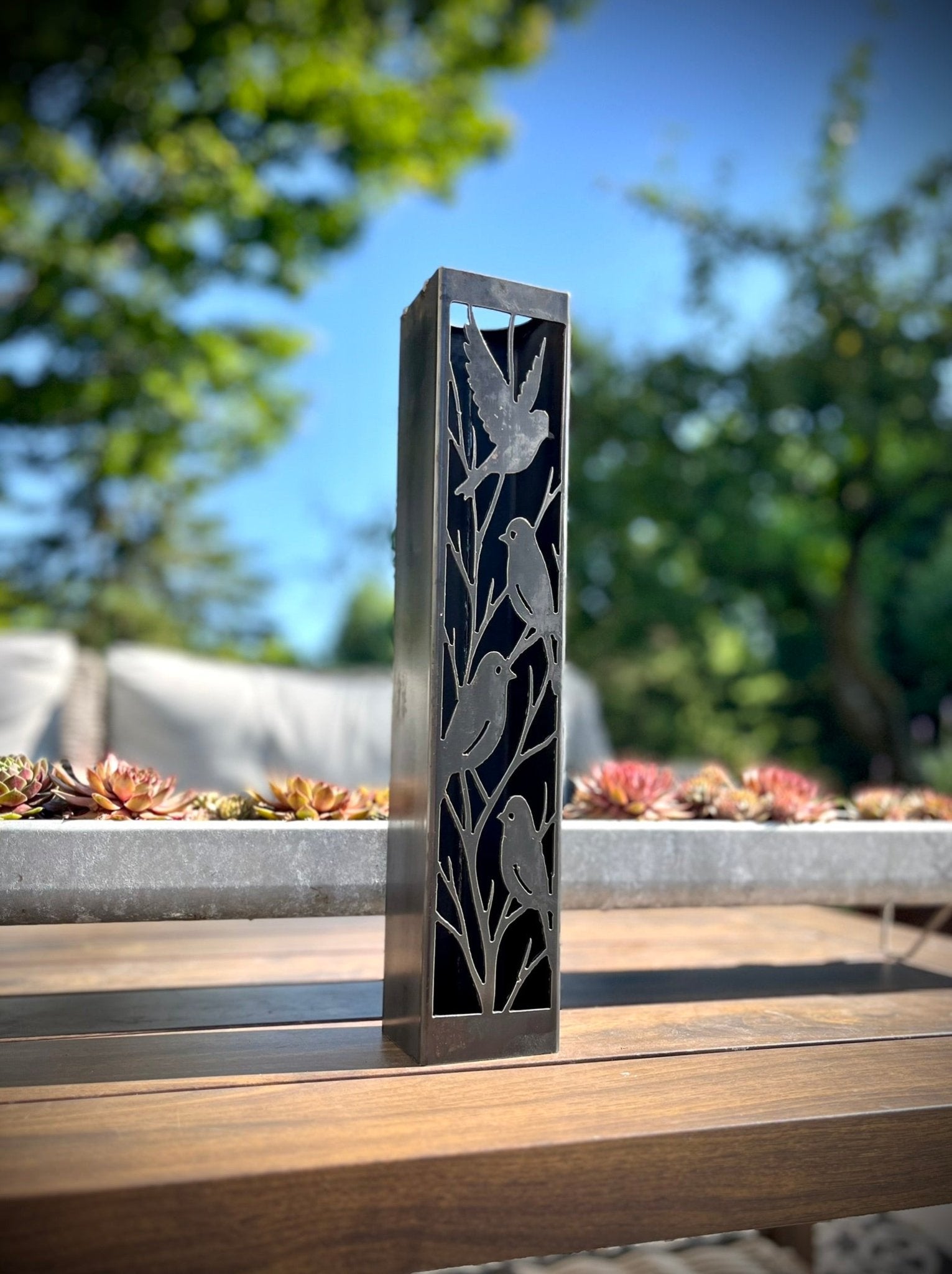 Outdoor Decorative Column with bird designs on a wooden surface outdoors