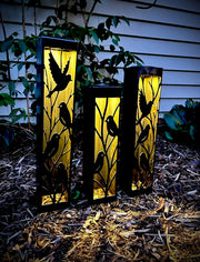 Three Outdoor Decorative Columns with bird designs on a natural ground surface.