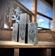 Three Garden Pillars with engraved designs on a wooden surface