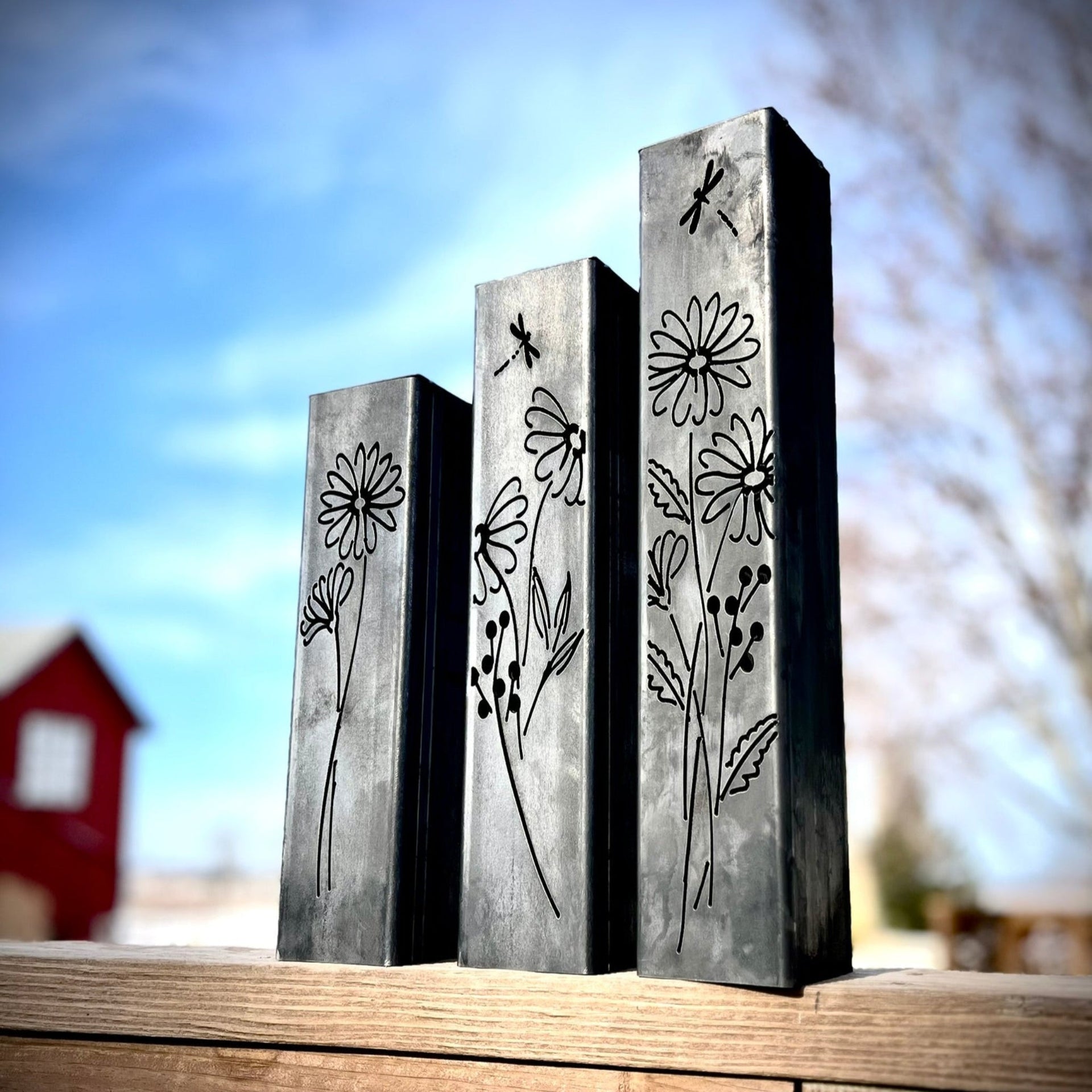 Outdoor Decorative Pillars with floral engravings on a wooden surface outdoors.
