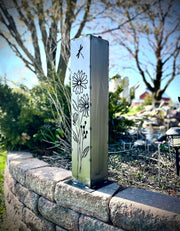 Outdoor Decorative Pillar with floral patterns on a stone wall in a garden setting