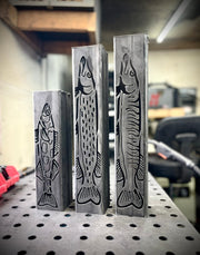 Three garden column pillars with fish engravings on a pegboard background
