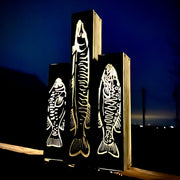 Garden column pillars with fish designs on a dark background