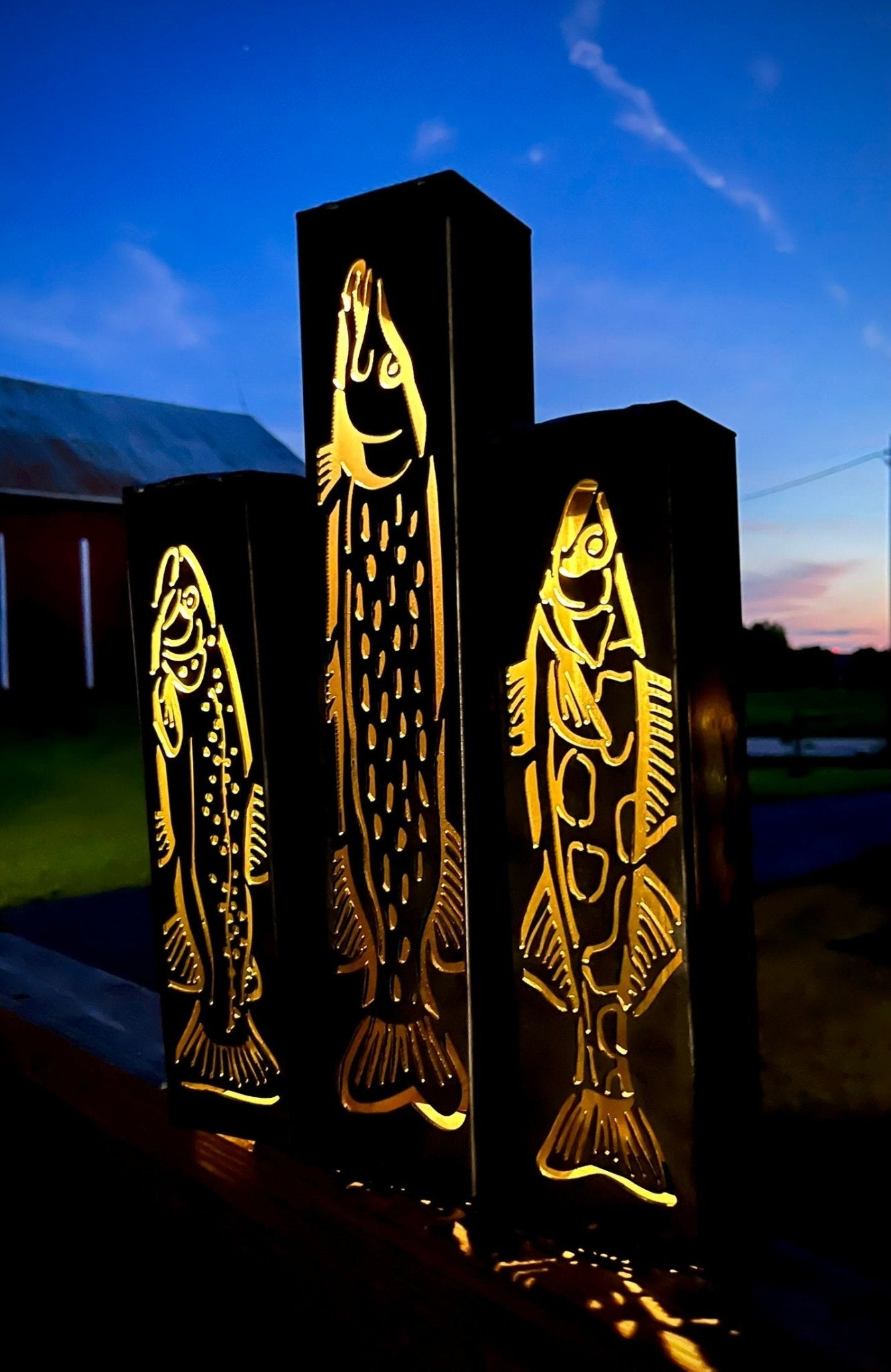 Decorative outdoor garden column pillarswith fish designs on a dark background