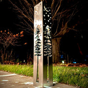 Decorative outdoor garden column with celestial design on a dark night.