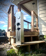 Outdoor garden column with palm tree and moon designs on a wooden surface. with palm tree and moon design on a wooden structure.