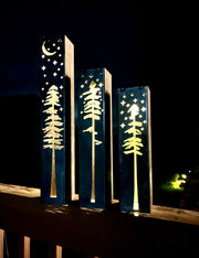 Decorative metal pillars with tree and moon design on a dark background