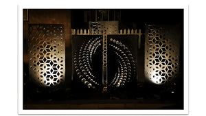 Decorative metal panels with geometric patterns in a dark setting.