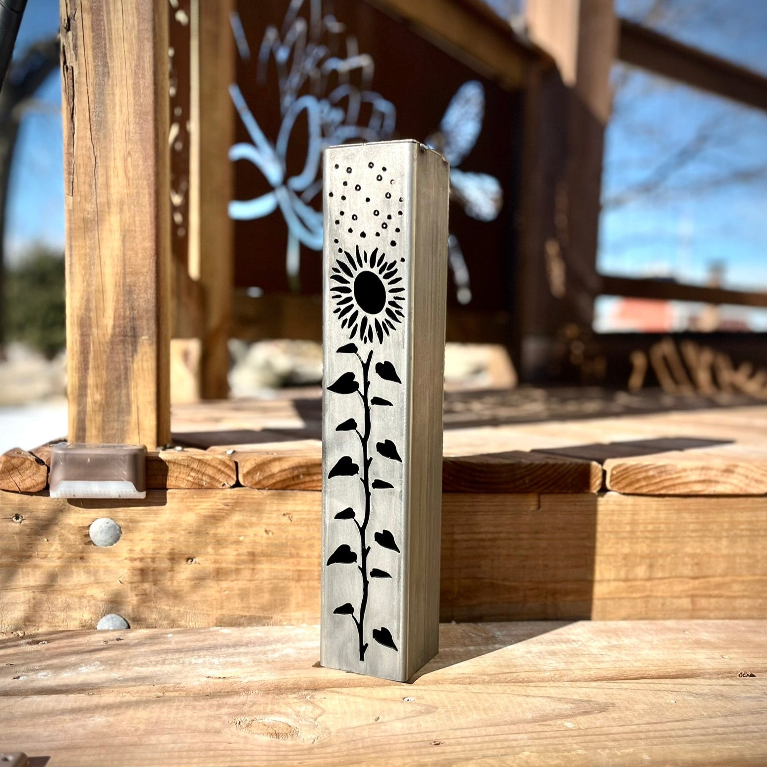 Garden Pillar with sunflower design on a wooden surface