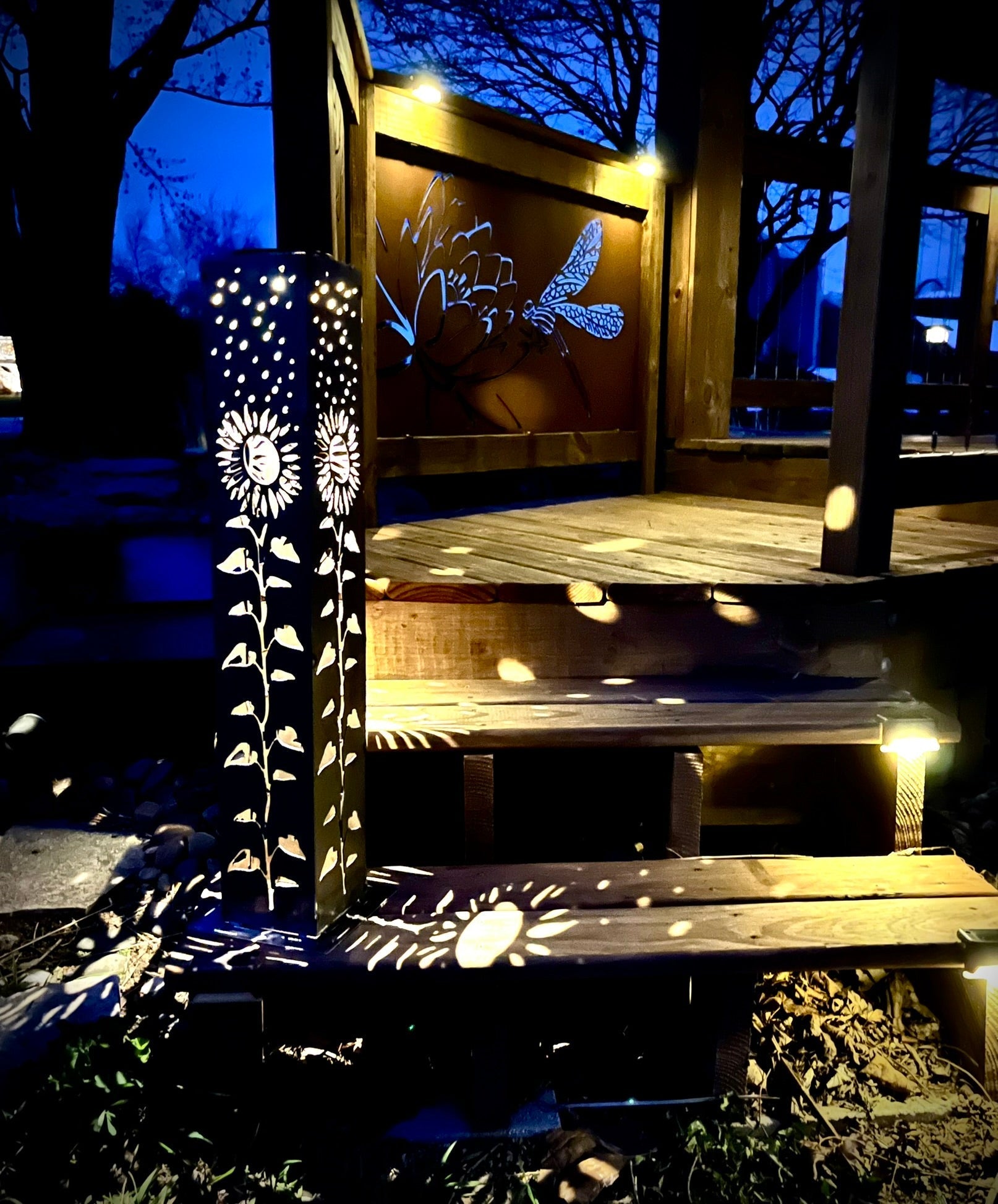 Decorative Garden Column Pillar with floral patterns on a wooden structure at night.