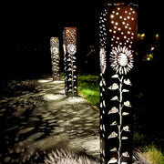 Decorative Garden Column Pillar with floral patterns on a pathway at night.
