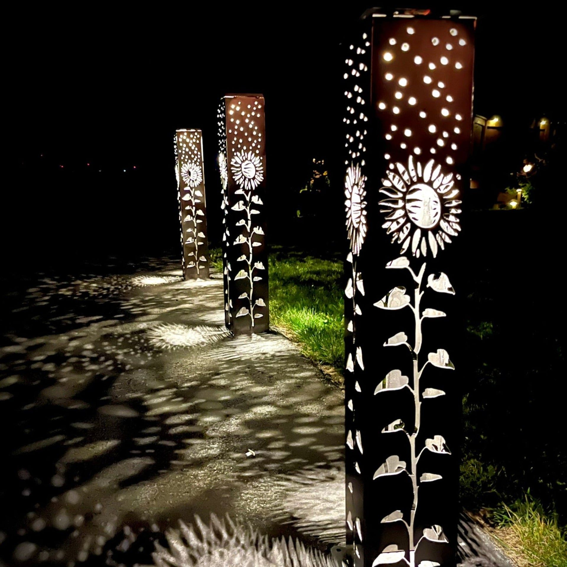 Decorative Garden Column Pillar with floral patterns on a pathway at night.